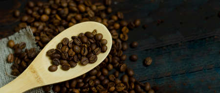 Top view, wooden spoon with coffee beans on rustic coffee background, copyspace.の写真素材