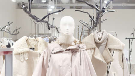 Female mannequin in a light autumn coat