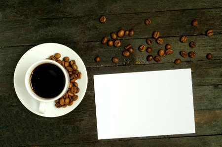 a cup of coffee with coffee beans on wooden table.Flatlay, mock up.