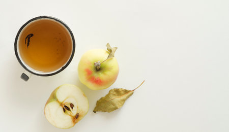 an old metal cup of apple juice and apple composition on white background.の写真素材