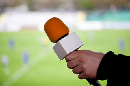 hand hold microphone for  interview during a football mach