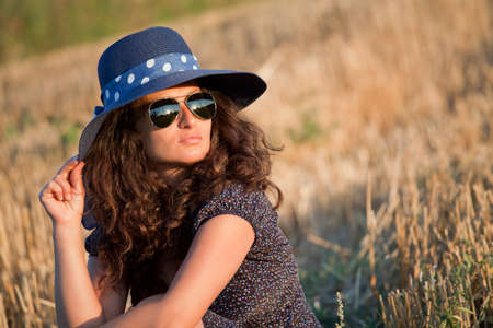 Portrait of a young woman with hat and sunglasses の写真素材