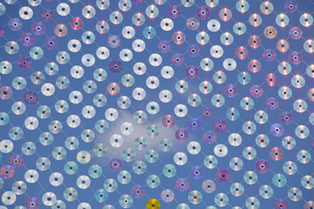 Net of old CDs and DVDs, against a cloudy sky
