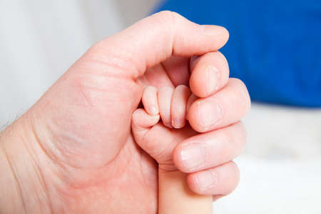 holding a hand of the newborn childの写真素材