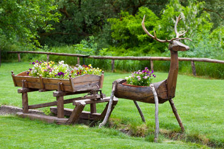 Summer flowers in wooden deer with sleighの写真素材