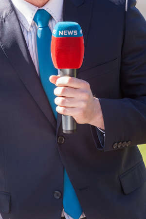 news journalist with microphone reportingの写真素材