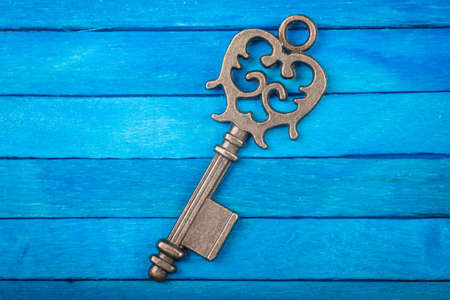 Old key on a blue wooden backgroundの写真素材
