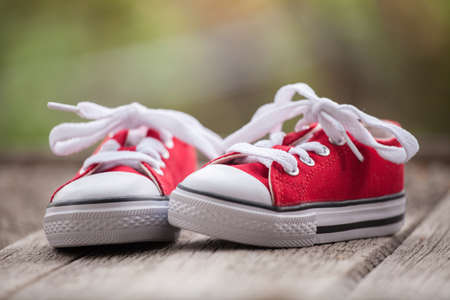 Red baby sneakers on wooden backgroundの写真素材