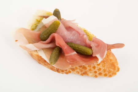 Spanish food tapas.Toast with prosciutto and small gherkinsの写真素材