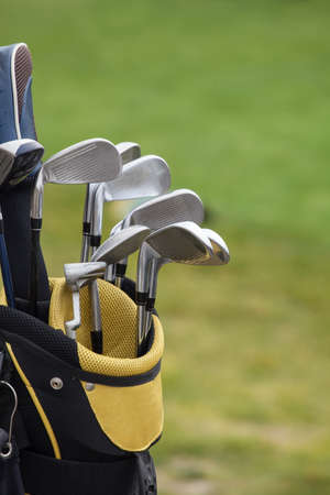 set of golf clubs over green field backgroundの写真素材