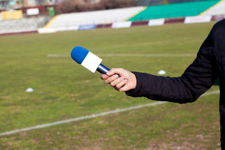 hand hold microphone for  interview during a football machの写真素材