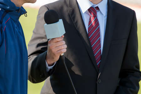 news journalist with microphone interviewingの写真素材