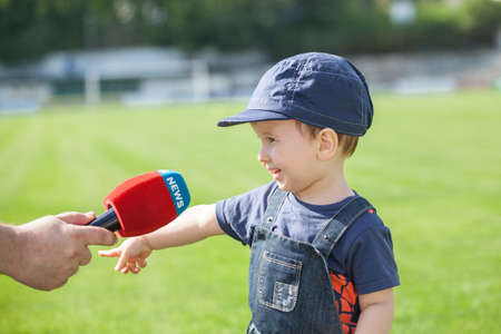 Little boy giving a interview on the field. After the matchの写真素材