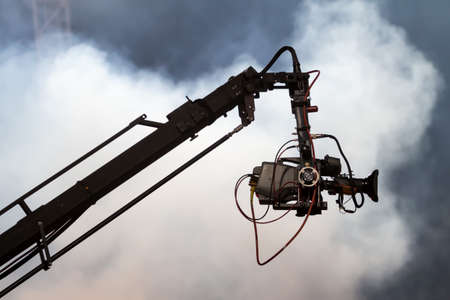 TV camera on a crane on football mach or concertの写真素材
