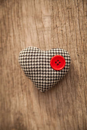 heart with red button over a wooden backgroundの写真素材