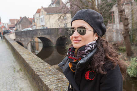 Woman tourist along canal in Bruges, Belgiumの写真素材
