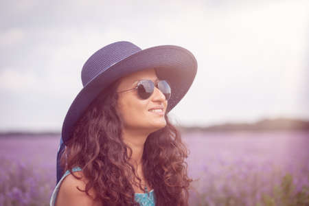 Beautiful girl with hat, enjoying the lavender fieldの写真素材