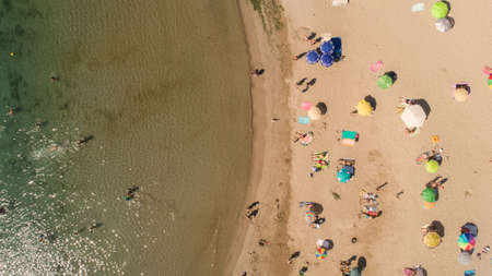 Top down view of beach with tourists and umbrellas with clear water. Tropical beach with colorful umbrellas. Holiday conceptの写真素材
