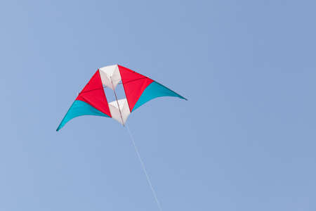 colorful kite flying in a beautiful blue skyの写真素材
