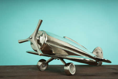Metal vintage aircraft toy, with front propeller. Retro toy on wooden board