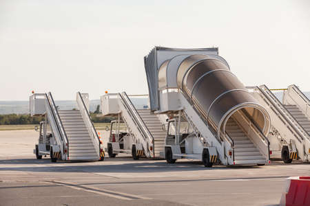 Gangways of airplan at the airport. Passenger's boarding ramps. Passenger's ladders. Traveling and waiting for flight at the airportの写真素材