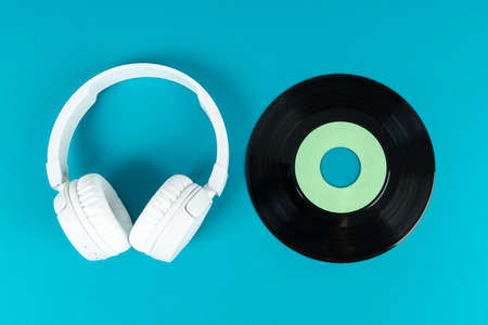 White wireless headphones and old vinyl record. Music concept. Rretro sound systemの写真素材