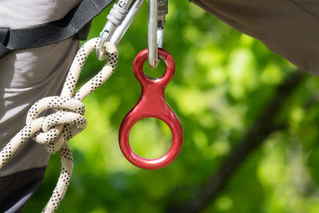 Close up rock climber, rope and climbing equipment. Carabiner with rope