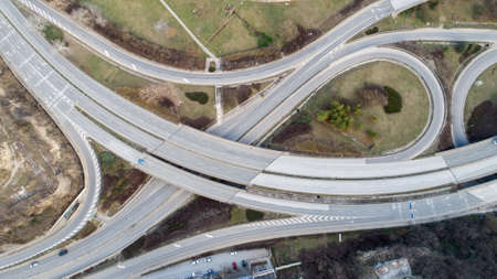 Top down view of highway multi level junction road with moving cars. View of traffic jam passing...