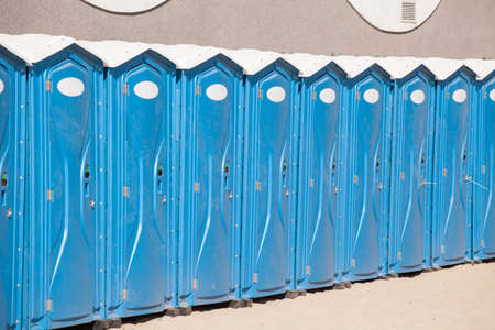 Row of blue portable, mobile toiletsの写真素材