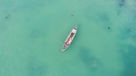 Lonely fishing boat in turquoise ocean, sea. Aerial photo, top viewの写真素材