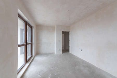 New empty room under construction. Plaster walls. New home. Concrete walls. Interior renovation.