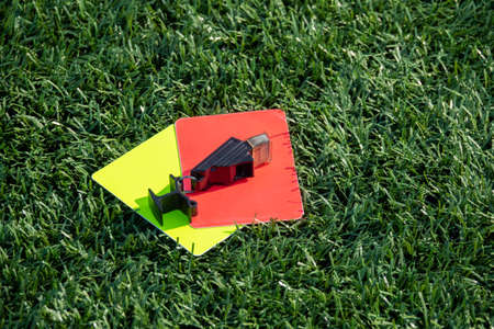 Referee soccer, football game whistle, red and yellow cards on green grass. Two penalty cards and a whistle for the referee  Fの写真素材