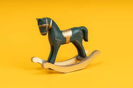 Blue vintage rocking horse on yellow backgroundの写真素材