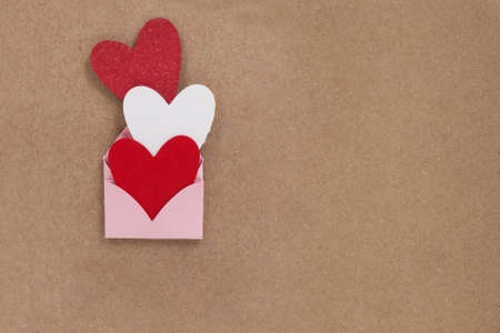 Valentine card. Handcrafted card expressing love. invitation card for wedding. Three hearts with envelope.の写真素材