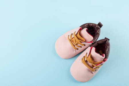 Pink baby shoes on blue background. Fashion for kids background concept. View from the top