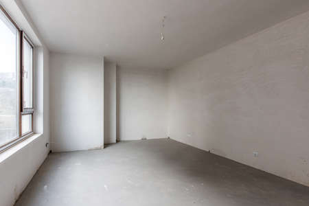 New empty room under construction. Plaster walls. New home. Concrete walls. Interior renovation.