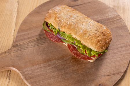 Sandwich with meat, salad, and cheese on a wooden board. Chabataの写真素材