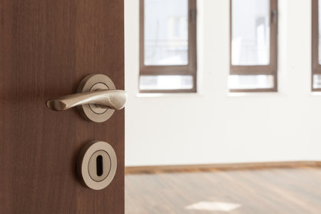 Half opened door to a ampty room. Door handle, door lock. Welcome, to new home conceptの写真素材