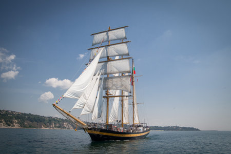 Old ship with white sales, sailing in the seaの写真素材