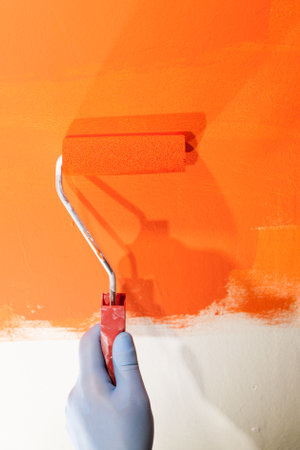 Painting a wall with roller in orangeの写真素材