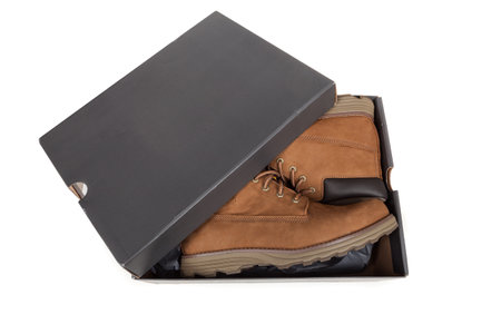 New men's brown leather boots in the box. Stylish winter shoes , isolated on white