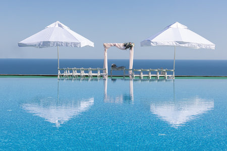 Wedding decor chairs ceremony near pool and sea. White chairs and wedding arch.の写真素材
