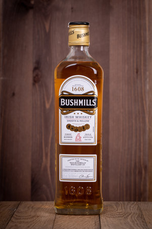 VARNA, BULGARIA - MARCH 16, 2020: Bushmills whiskey bottle on wooden background. Bushmills whiskey distillery was founded in 1784.のeditorial素材