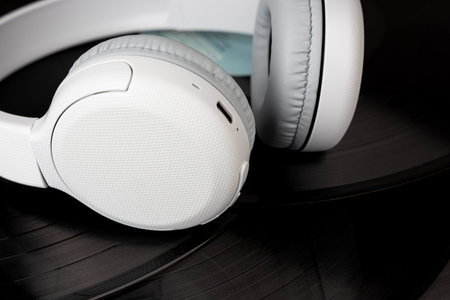 White wireless headphones on old vinyl records. Music concept. Rretro sound systemの写真素材