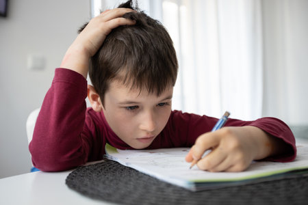 Portrait of young boy struggling with his homework at home. Children home education concept....