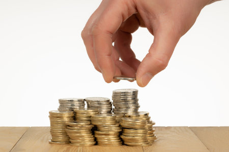 Man hand put money coins to stack of coins. Money savings, investment, financial wealth management...