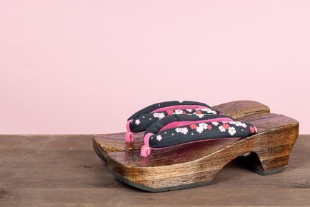 Japanese traditional geta sandal on pink background. Traditional Japanese asian wood footwear called Getaの写真素材