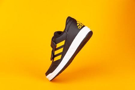 Varna , Bulgaria - AUGUST 13, 2019 : ADIDAS ALTA SPORT  shoe, on yellow background. Product shot. Adidas is a German corporation that designs and manufactures sports shoes, clothing and accessoriesのeditorial素材