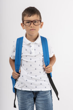 Little schoolboy with schoolbag, backpack and glasses. Unhappy. Going to school. Back to schoolの写真素材