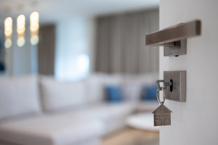 Open door to a new home with key and home shaped keychain. Mortgage, investment, real estate, property and new home concept. Welcome home.の写真素材